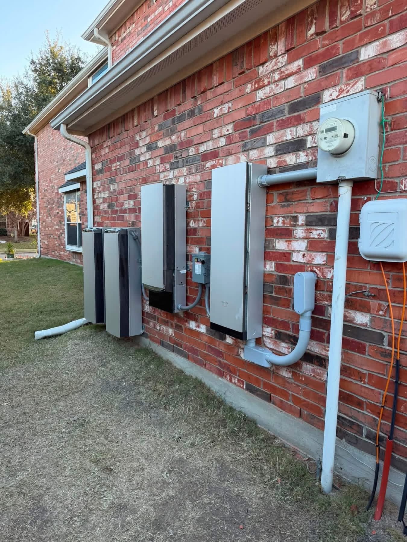 EcoFlow home battery system installed on a red brick Texas home exterior